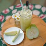 Chilled guava juice with slices served on a wooden tray in a charming Dalat café setting.